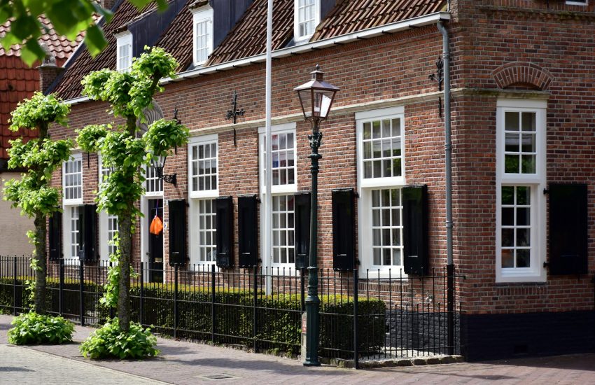 a row of brick buildings with whitwindows