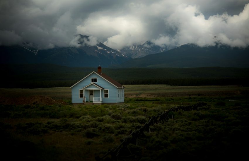 house on grass field under gray sky