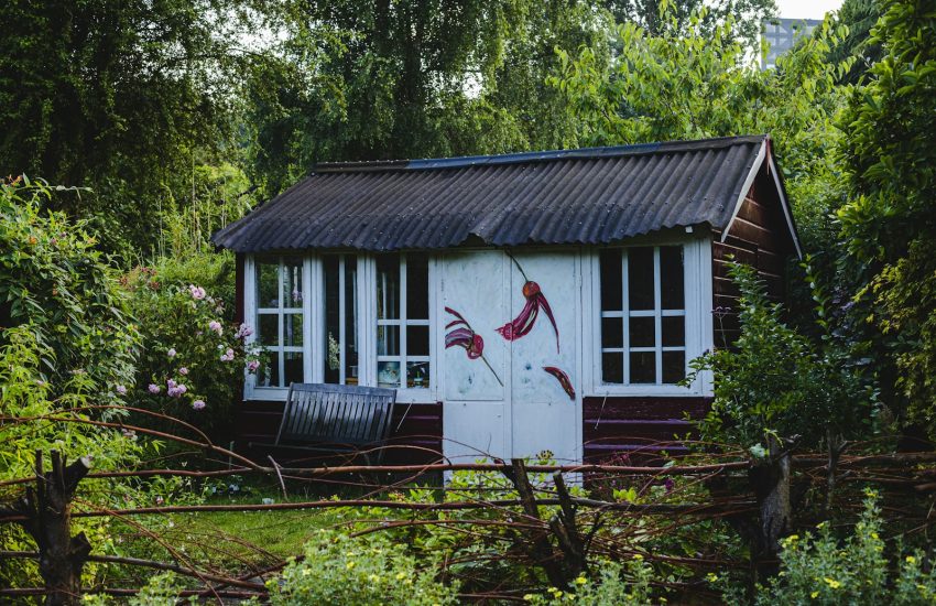 white and red wooden house surrounded by green trees during daytime